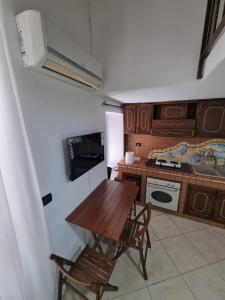 a kitchen with a wooden table and two chairs at B&b casa (le porte di napoli) in Naples