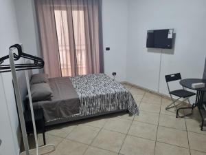 a bedroom with a bed and a table and a television at B&b casa (le porte di napoli) in Naples