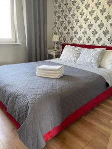 sypialnia z dużym łóżkiem z czerwonym zagłówkiem w obiekcie Apartament Centrum w Lidzbarku Warmińskim