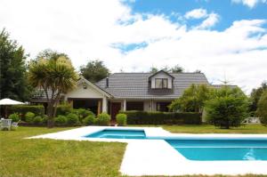 ein Haus mit einem Swimmingpool im Hof in der Unterkunft Merken Bed & Breakfast in Villarrica
