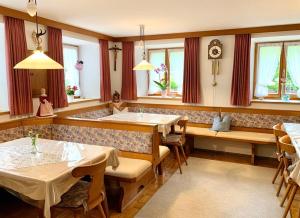 a restaurant with two tables and chairs and windows at Haus Jagerer in Ramsau