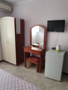 a room with a desk with a mirror and a television at Guest House Konomaevi in Sozopol