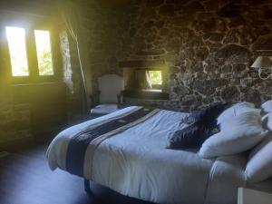 łóżko w pokoju z kamienną ścianą w obiekcie As Alburiñas w mieście Bolmente