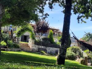 dom w ogrodzie z drzewami i trawą w obiekcie As Alburiñas w mieście Bolmente