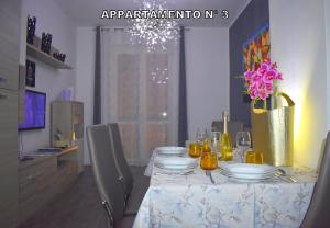 a dining room table with plates and flowers on it at Red & Blu Apartments in Desenzano del Garda