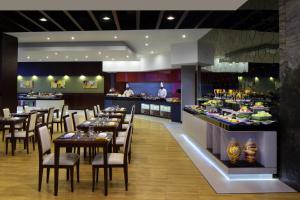 un restaurante con mesas y sillas y un bar en Millennium Central Downtown, en Dubái