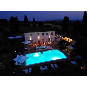 - une piscine en face d'une maison la nuit dans l'établissement Villa Casa Collina Castelfalfi with amazing salt waterpool & AIRCO & VIP service, à Castelfalfi