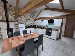 - une cuisine avec une table et des chaises en bois dans l'établissement Les Coccinelles, à Adilly