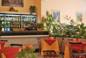 een restaurant met een bar met veel planten bij Hotel Galleano in Marina dʼAndora