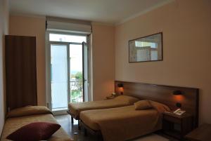 een hotelkamer met twee bedden en een raam bij Hotel Galleano in Marina dʼAndora +32 foto's