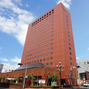 a tall red brick building on a city street at Hotel New Carina in Morioka