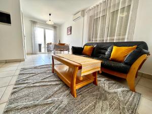 a living room with a black couch and a table at Apartments Lokunja in Pag