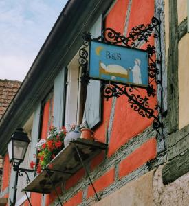 ein Schild für eine Bar an der Seite eines Gebäudes in der Unterkunft ANNO 1698 Gîtes et Chambres d'Hôtes in Beblenheim