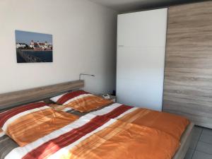 ビンツにあるResidenz Binzのベッドルーム1室(オレンジ色の掛け布団付きのベッド1台付)