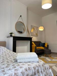 1 dormitorio con cama con espejo y sofá en Le Petit Gayant, en Douai