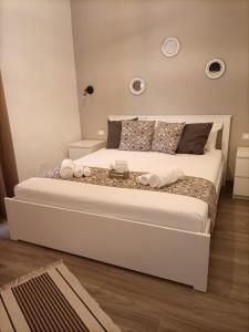 a bedroom with a large white bed with towels on it at AL CIVICO 1 APARTMENTS in Trapani