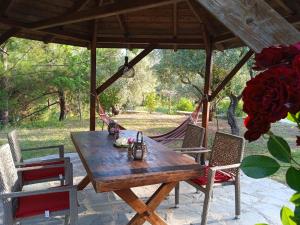 a wooden table and chairs under a gazebo at FANTASY GRAND VILLA THASSOS in Astris