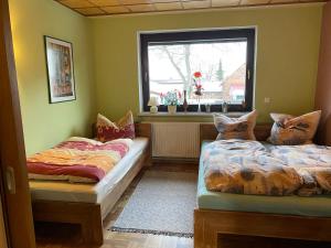 two beds in a room with a window at Ferienwohnung Erfurt Marbacher Höhe in Erfurt