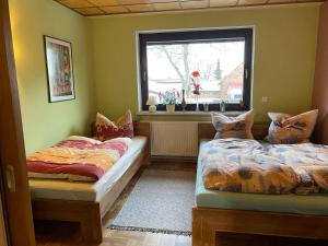 dwa łóżka w pokoju z oknem w obiekcie Ferienwohnung Erfurt Marbacher Höhe w mieście Erfurt