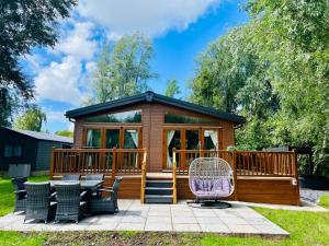 a gazebo with a deck and chairs in a yard at Fairhaven lodge Free Wifi & Hottub in Warton