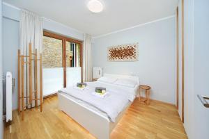 - une chambre blanche avec un lit et une fenêtre dans l'établissement Apartment Medvědín 331/409, à Špindlerův Mlýn