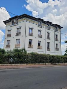 a large white building with windows on a street at Appartement meublé rénové idéal pour curistes ou vacanciers in La Roche-Posay