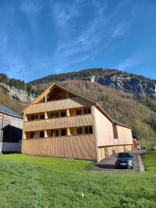 a building with a car parked in front of it at Bergluft Apartment MELLAU in Mellau