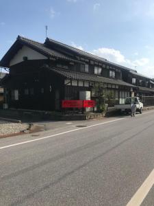 um edifício preto e branco na berma de uma estrada em Kishida House - Vacation STAY 78228v em Nagahama