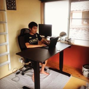 un joven sentado en un escritorio con un portátil en Kishida House - Vacation STAY 78228v, en Nagahama