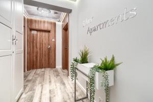 a hallway with potted plants in front of a door at Silver Apartments in Świnoujście