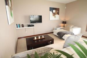 ein Wohnzimmer mit einem Sofa und einem TV in der Unterkunft The House of Origin in Costa Teguise