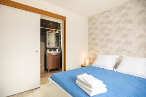 阿热莱斯加佐斯特Appartement cocooning avec vue sur les Pyrénées的卧室里有一张蓝色的床，床上放着毛巾