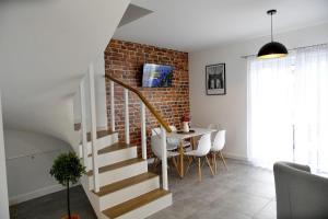 escalera en una sala de estar con mesa y pared de ladrillo en Domki na Krótkiej, en Spytkowice