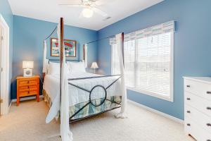 a blue bedroom with a bed with a canopy at Eagles Landing - 4300 Sandpiper #4314 in Rehoboth Beach