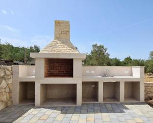 cocina al aire libre con chimenea y fregadero en Orkula Apartments, en Pašman