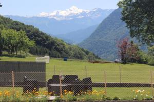 Ein Zaun auf einem Feld mit Bergen im Hintergrund in der Unterkunft Chez Gilles et Christine in Mieussy