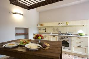 a kitchen with a wooden table with bowls of fruit on it at B&B La Ceramica Moline in Vicoforte