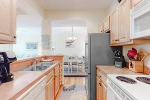 a kitchen with wooden cabinets and a stainless steel refrigerator at Eagles Landing - 4300 Sandpiper #4314 in Rehoboth Beach