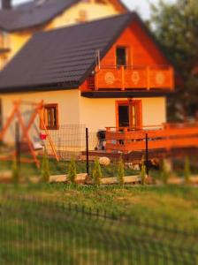 a small house with a fence in front of it at Domek u Basi in Czorsztyn