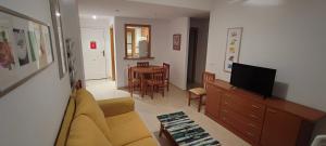 sala de estar con sofá, TV y mesa en Costa de Marfil I-SERVHOUSE, en Castellón de la Plana