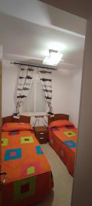 una camera da letto con due letti singoli e una finestra di Costa de Marfil I World, Hermoso - ServHouse a Castellón de la Plana Altre 13 foto