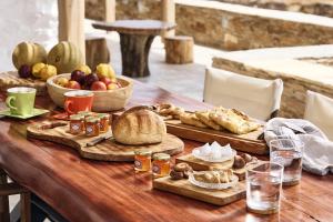 a wooden table with bread and other food on it at Kozadinos Art Suites in Kithnos