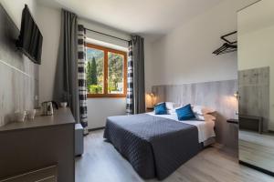 una camera d'albergo con letto e TV di Hotel Canarino a Riva del Garda
