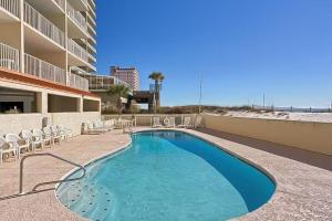 una piscina con sillas y un edificio en Clearwater 8B en Gulf Shores