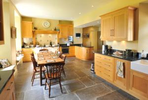a large kitchen with a wooden table and chairs at Carsaig House in Pennyghael