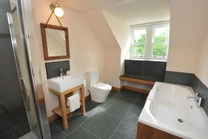 a bathroom with a sink and a toilet and a mirror at Achaglachgach Stables in Tarbert +28 photos