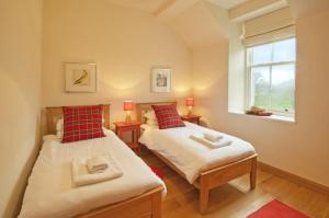 two beds in a small room with a window at Achaglachgach Stables in Tarbert