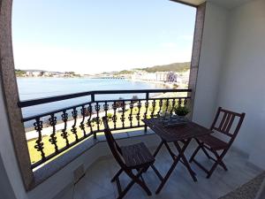 a balcony with a table and chairs and a view of the ocean at Ría de Viveiro 2 in Viveiro