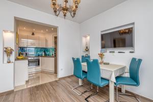 cocina y comedor con mesa y sillas azules en Award winning Garden Apartment with large Terrace and amazing Seaview, en Bol