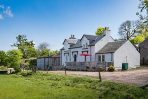 una casa con un frisbee rojo delante de ella en The Old Farmhouse, en Balloch